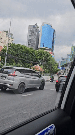 Bangkok street traffic with distinctive architecture in the background