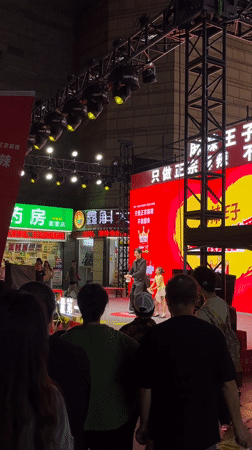 Father-daughter duo performs on outdoor stage in Jiulongpo District