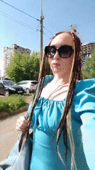 Person in blue dress walks through sunny Izhevsk park