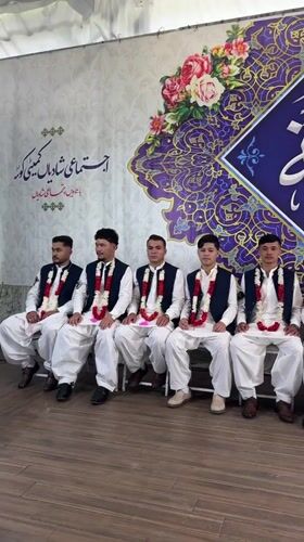 Formal ceremony with garlanded men in traditional dress, Quetta