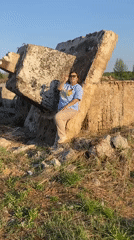 Woman poses on concrete rubble in Russian field