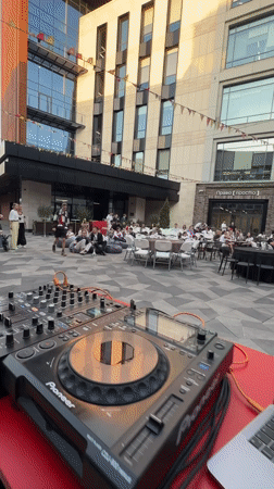 Casual outdoor DJ event observed in Kazan amid modern architecture