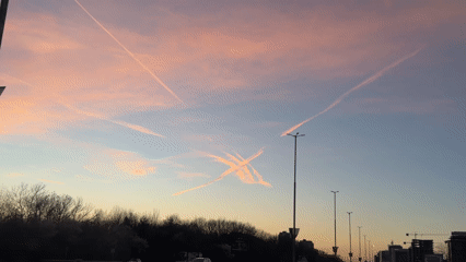 Aircraft contrails form crossing patterns over Sofia evening sky
