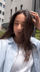 Woman records outdoor selfie videos in sunlit Milan