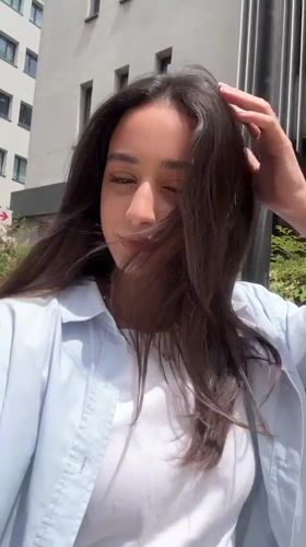 Woman records outdoor selfie videos in sunlit Milan