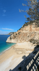 Tourist documents scenic Kaputaş Beach views in Kaş, Turkey