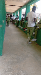 Young men gather in institutional hallway during morning hours