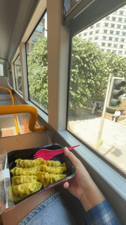 Passenger eats dumplings with pink fork on London bus