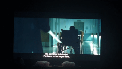 Television screen shows hospital scene with wheelchair patient