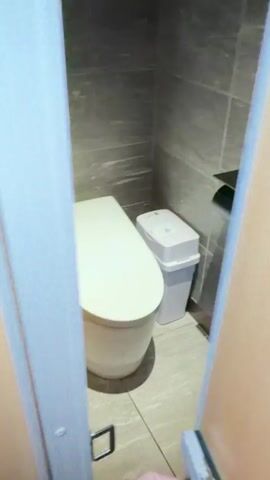 A video shows a toilet with a closed lid. The lid then opens, revealing a blue light inside the toilet bowl.