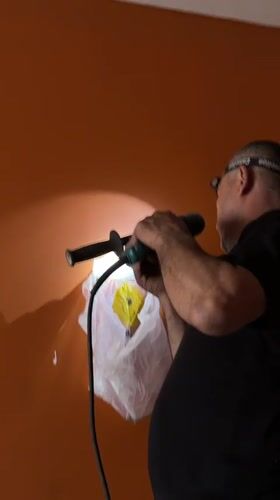 Man drills orange wall in Khimki, Russia