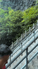 Tourists climb stone stairs to rock formations in Zhangjiajie