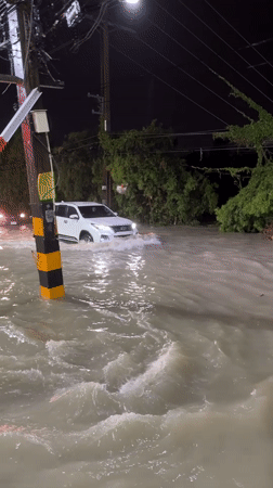 Vehicles navigate deep nighttime flooding in Pattaya City