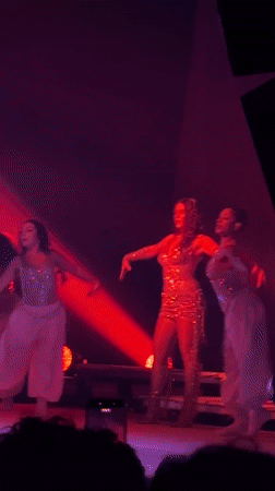 Singer performs with dancers at Milan concert venue