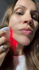 Woman uses LED beauty device during skincare routine in Fethiye