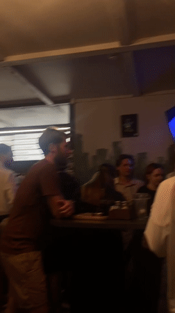 Bar patrons gather, review beer menu in Rusanovo