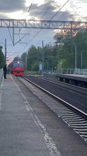 Evening commuter train activity documented at Komarovo station, Russia