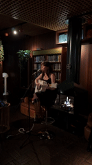 Female musician performs acoustic set in London venue