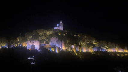Veliko Tarnovo castle illuminated with changing colored lights at night