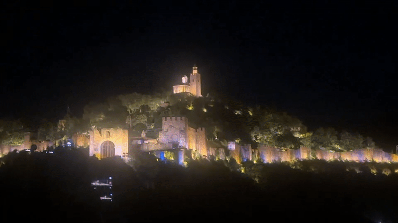 Veliko Tarnovo castle illuminated with changing colored lights at night