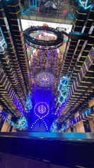 Crowd gathers in illuminated Moscow atrium with geometric decorations