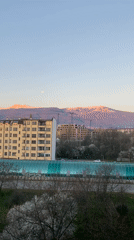 Sofia cityscape captured with snowy mountains, full moon visible