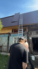 Men repair dilapidated building roof in Perm, Russia