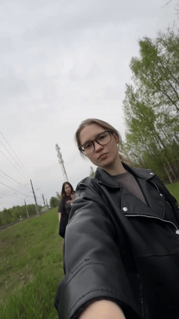 Two women film themselves near railway tracks in Solnechnoye