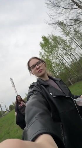 Two women film themselves near railway tracks in Solnechnoye