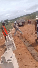 Workers conduct manual labor at rural construction site