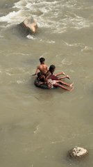 Inner tube riders on a murky, fast-flowing Acehnese river