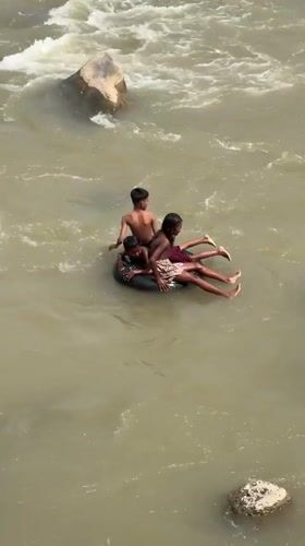 Inner tube riders on a murky, fast-flowing Acehnese river