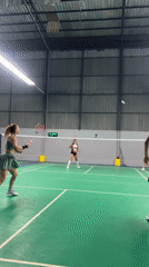 Recreational badminton game captured at indoor court in Thailand