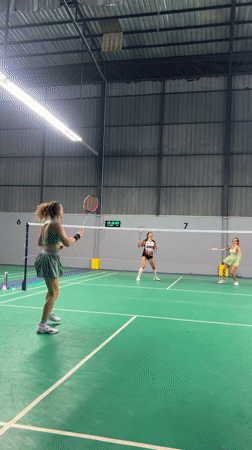Recreational badminton game captured at indoor court in Thailand