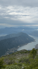 Cruise ships navigate Montenegro bay amid mountain scenery