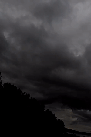 Storm clouds gather over Chaikovsky waterway, concrete structures visible
