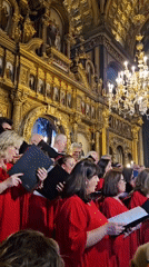 Red-robed choir performs in ornate golden church