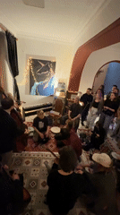 Group gathering on rugs observed in Tbilisi room