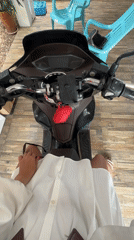 Woman prepares scooter departure in Thai garage early morning