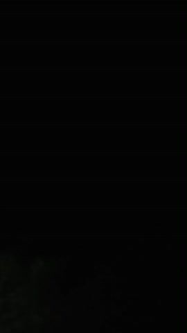 The video shows a dark sky with clouds and lightning. There are silhouetted trees in the foreground.
