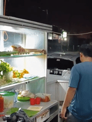 Street food vendors operate through heavy rain in Lhokseumawe