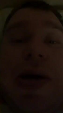 The video captures a close-up of a person's face, illuminated by a dim light source. The individual appears to be lying down, possibly in bed, as evidenced by the slightly angled perspective and the presence of what seems to be a pillow or bedding in the background. The lighting is low, creating shadows that obscure some of the facial features, but the eyes, nose, and mouth are discernible. The person's gaze shifts from looking directly at the camera to looking off to the side.

The audio consists of muffled speech, suggesting the person is speaking, but the words are not entirely clear. The phrase "света, ты где?" can be faintly heard, which translates to "Sveta, where are you?" in Russian. This indicates a question directed at someone named Sveta and implies a search or inquiry about her whereabouts. The context of the question suggests that the speaker might be looking for Sveta or trying to get her attention. The overall mood is intimate and perhaps a bit somber or inquiring due to the low light and the nature of the spoken words. The time of day is implied to be either late at night or early morning due to the dim lighting.