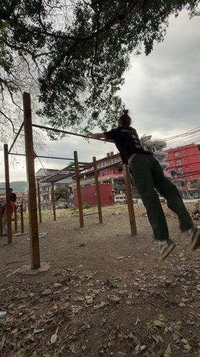Man performs somersault over pull-up bar in Pokhara park