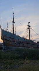 Three-masted tall ship docked at Lelystad harbor at dusk