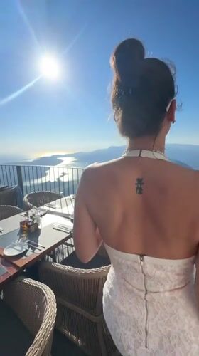 Woman dines at sunset terrace overlooking Montenegro coastline