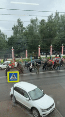 Flag-bearing marchers parade through wet Izhevsk streets