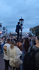 Ladder work on a street lamp draws a crowd in Brest