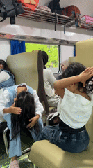 Train passengers share casual moments during late-night journey in Indonesia