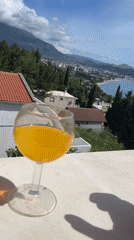 Person drinks Fanta overlooking Montenegro coastline