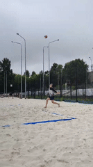 Beach volleyball game in progress on a cloudy day